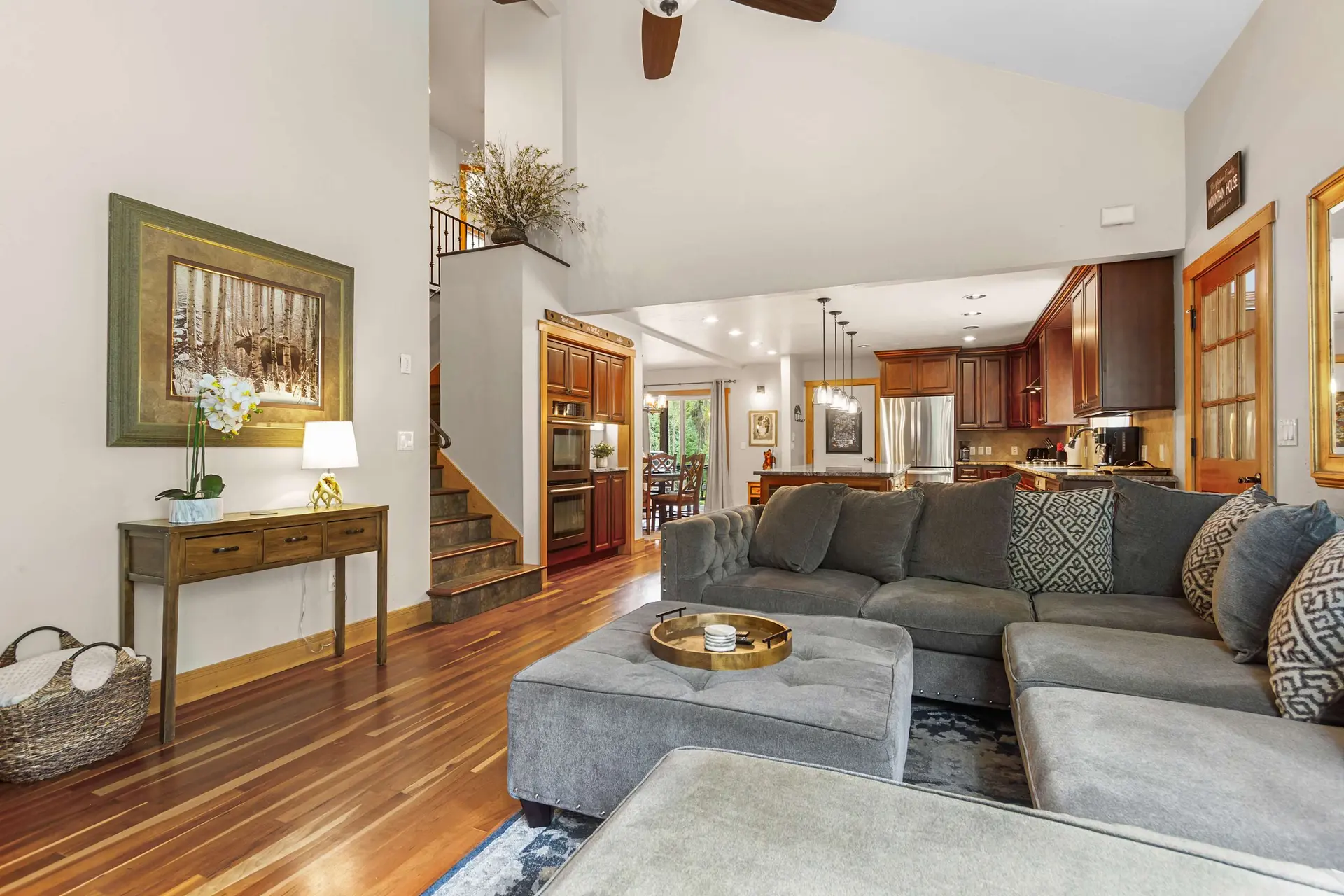 A modern living room with a sectional sofa and a view into the kitchen.